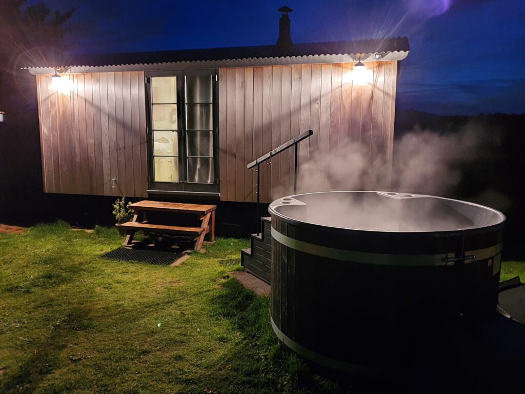 Image of the Shepherd's Hut at night with hot tub. Romantic Break in Yorkshire
